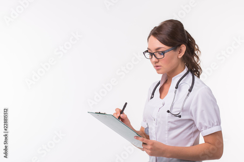Female medicine doctor hand holding pen writing something on clipboard on white background with copy space