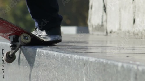 Skateboarder does the grind trick crooked on granit ledge on memorial