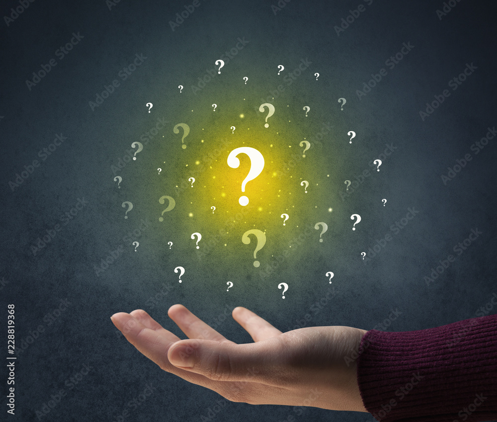 Yellow question marks hovering over young hand Yellow question marks hovering over young hand