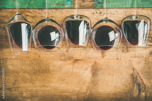 Bilde på lerret Flat-lay of red wine in glasses over rustic wooden tray background, top view, copy space