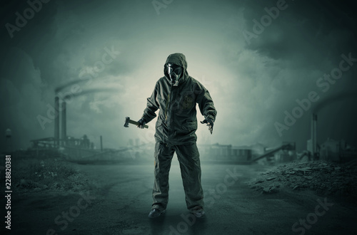 Gas masked survival man coming with arms on his hand  in a demolished dark environment 
 photo