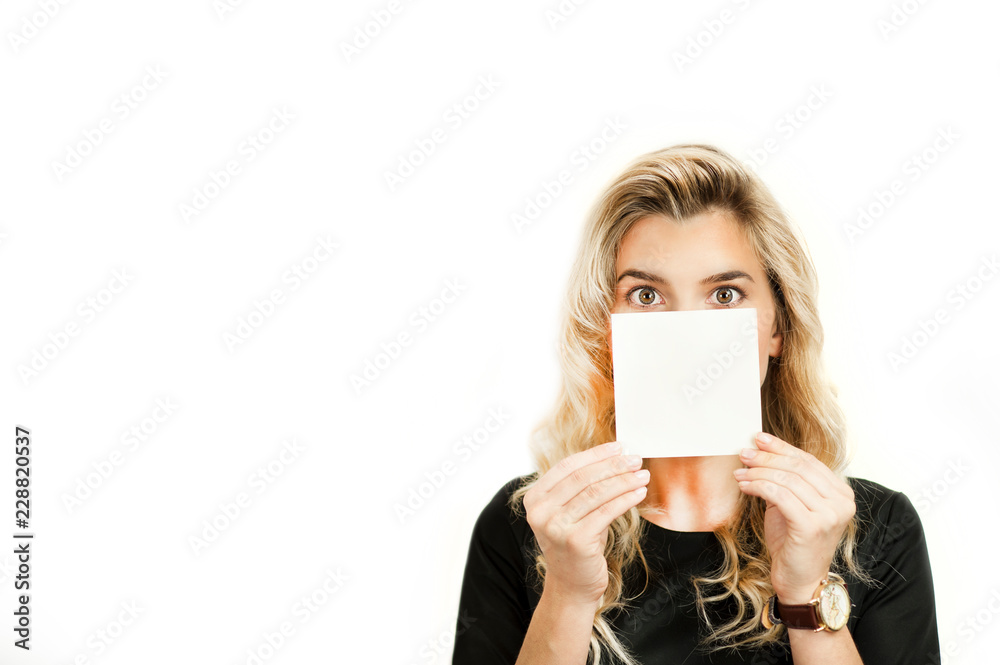 Surprised emotional beautiful young girl holding a blank advertisement sheet on white isolated background. Black Friday, shopping, discounts Surprised emotional beautiful young girl holding a blank advertisement sheet on white isolated background. Black Friday, shopping, discounts