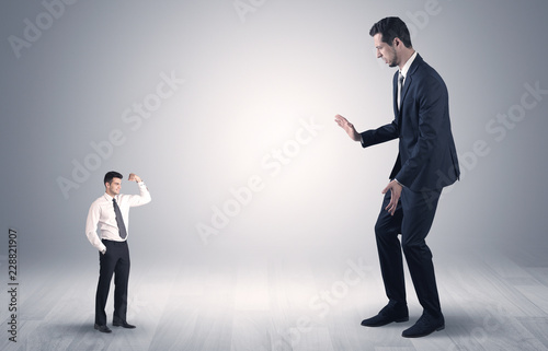 Big debutant young businessman scared of small strong businessman 