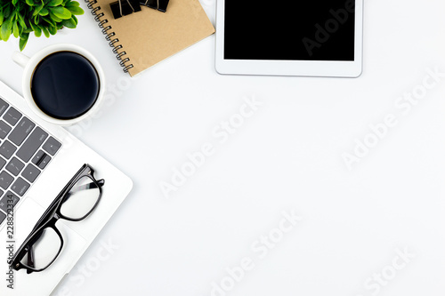 Top view of Office desk with workspace in office with blank notebook tablet and smartphone with other office supplies,with copy space.
