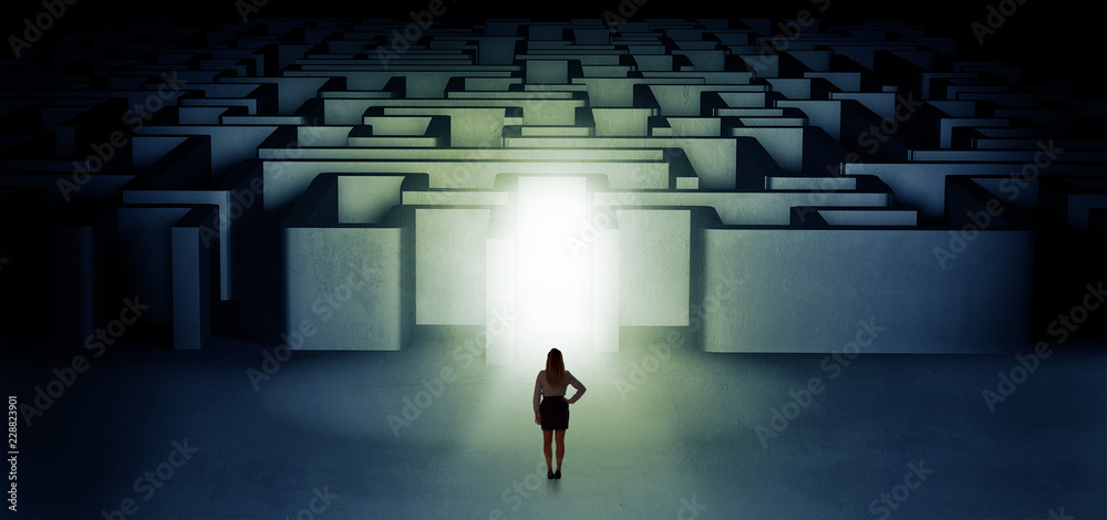 Lost woman standing at the dark labyrinth with illuminated door
Lost woman standing at the dark labyrinth with illuminated door