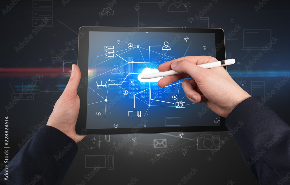 First person view of a hand using tablet with cloud office concept
First person view of a hand using tablet with cloud office concept