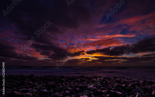 Sunrise on Praia de Igrejinh with dramatic colorful sky and rock  island of Sal near Santa Maria  Cabo Verde