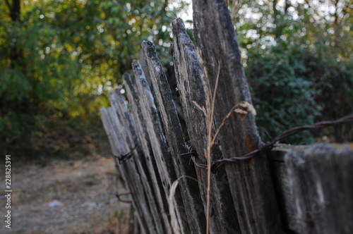 Barb wire on a wooden fence in the village