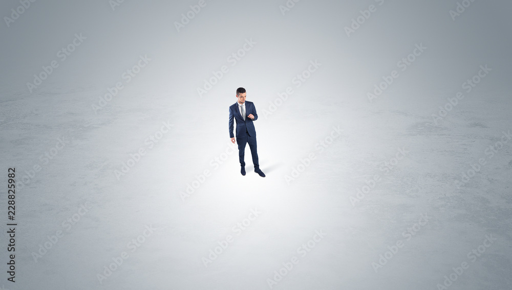 Young businessman standing alone in the middle of an empty space
Young businessman standing alone in the middle of an empty space