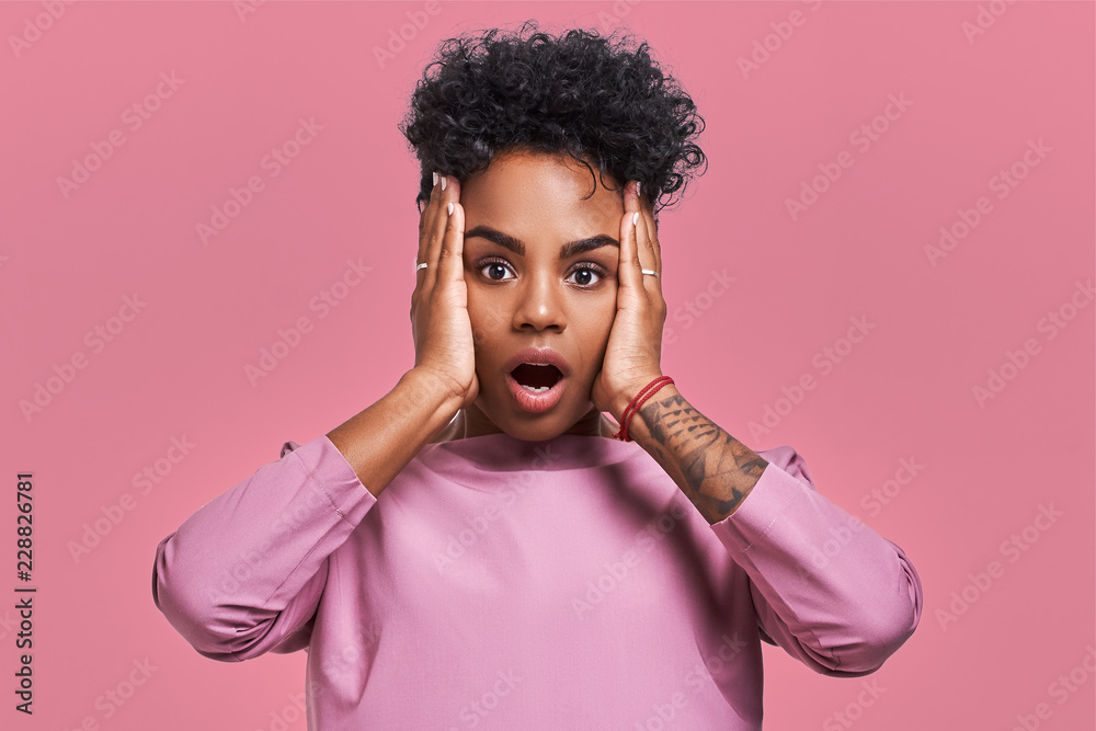 Young Lovely Dark Skinned Female Has Curly Hair Looks Surprisingly At Camera Keeps Jaw Dropped Wonders Sudden News Poses Against Pink Background Facial Expressions Stock Photo Adobe Stock