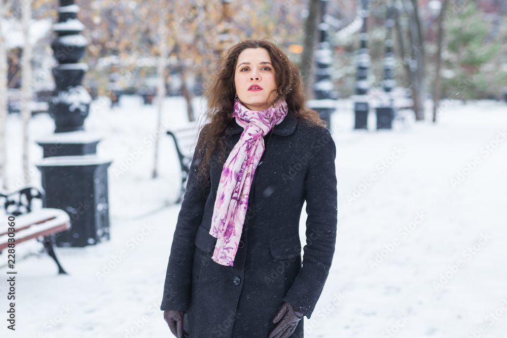 Winter, fashion and people concept - Portrait of young woman is taking a walk outdoors