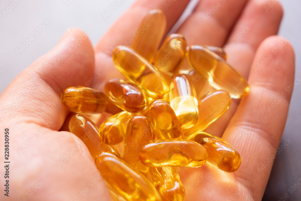 man hand holding an Omega 3 fish oil capsules man hand holding an Omega 3 fish oil capsules