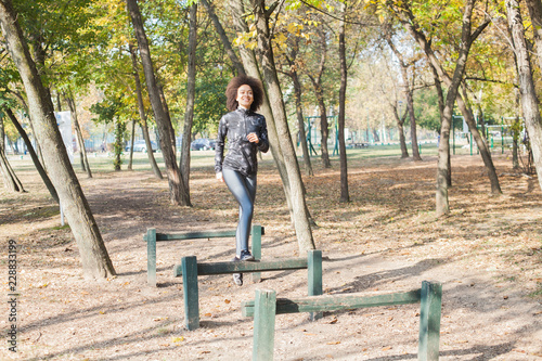 African Woman Running And Jumping Over Hurdles In Forest