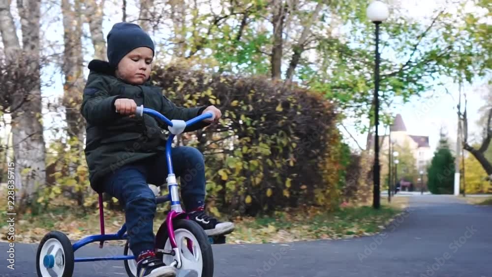 Child rides a bicycle. First bike for little child. Active toddler kid playing and cycling outdoors. Child rides a bicycle. First bike for little child. Active toddler kid playing and cycling outdoors.