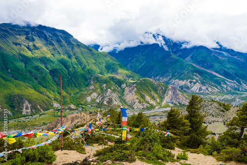 Traditional buddhist prayer flags over foggy mountain background in Ngawal, Nepal