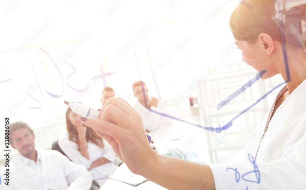 Naklejka premium view through the transparent Board. female biochemist makes a report to colleagues