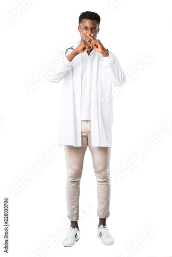Full body of African american doctor showing a sign of closing mouth and silence gesture on white background