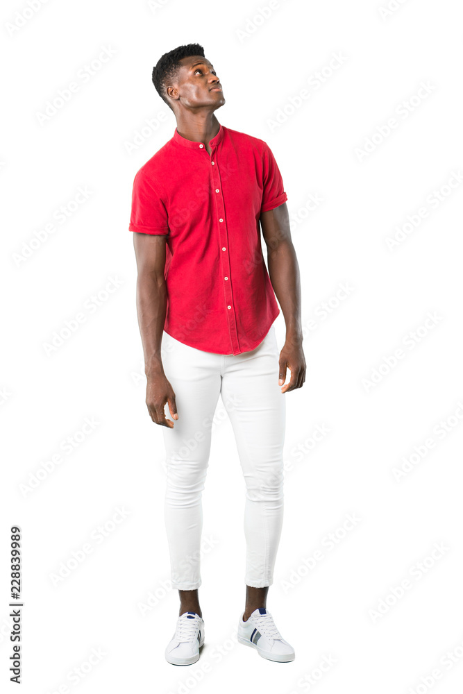 Full body of Young african american man stand and looking up with serious face on white background Full body of Young african american man stand and looking up with serious face on white background
