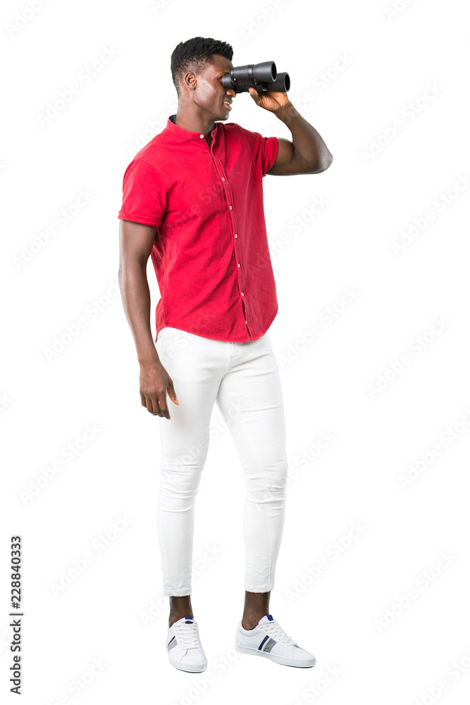 Full body of Young african american man and looking for something in the distance with binoculars on white background Full body of Young african american man and looking for something in the distance with binoculars on white background