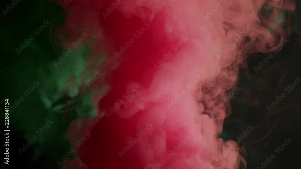 green and pink bomb smoke on black background