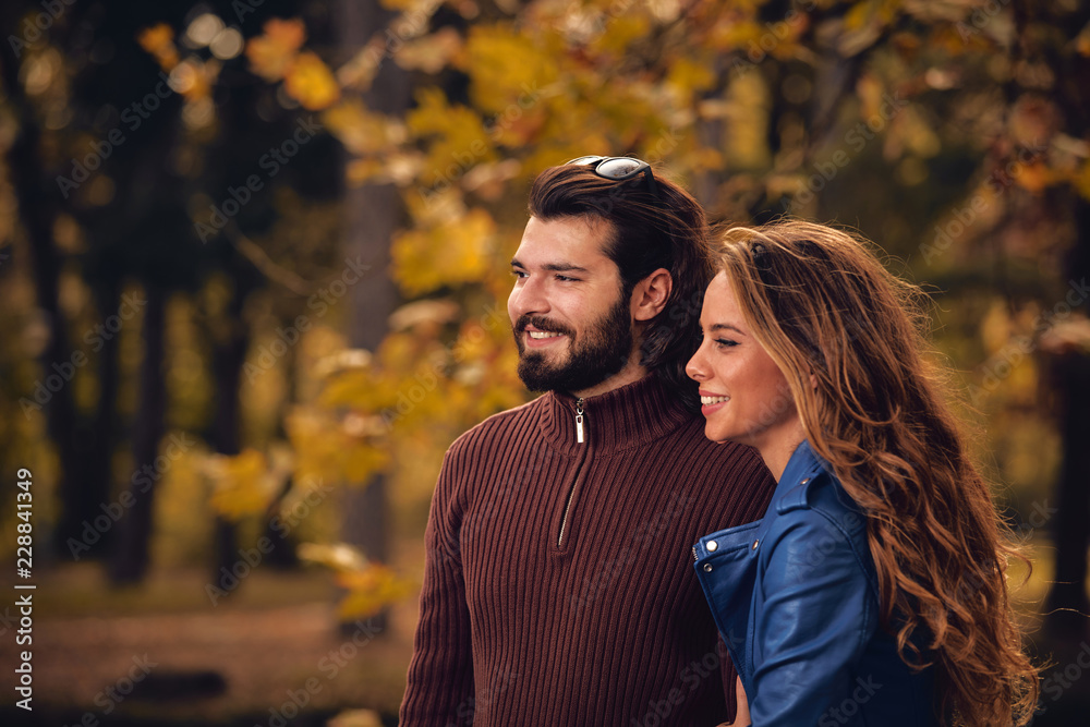 Fototapeta premium Couple in autumn season colored park enjoying outdoors.