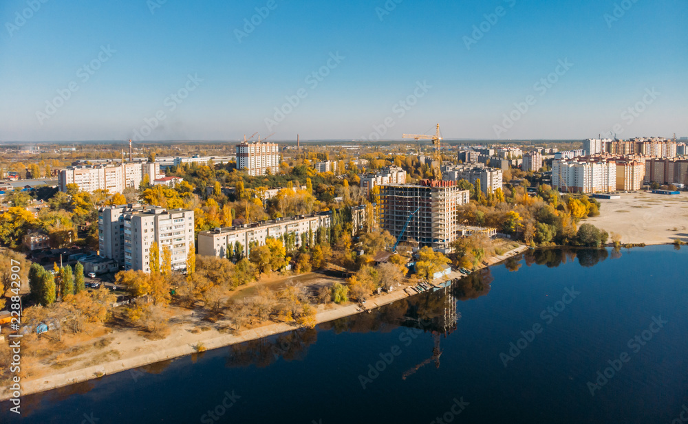 Aerial panoramic view of cityscape with river in sunny day, autumn city landscape from above