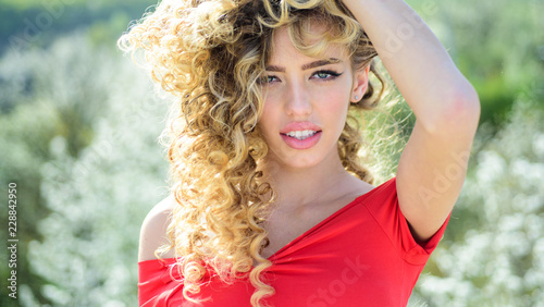 Blonde with curly hairstyle and red lips. Beautiful model with curly hair. Fashion haircut. Trendy haircuts. photo