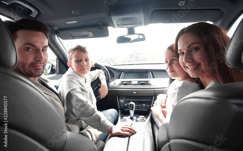 cheerful family sitting in the car