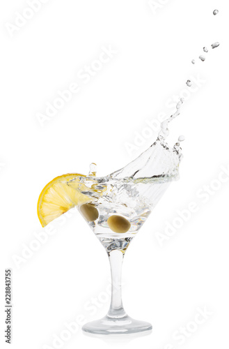 Martini splash with lemon and green olives in a transparent cock
