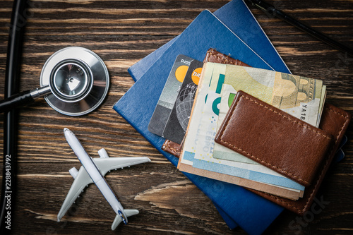 Fototapeta Medical tourism concept - passports, stethoscope, airplane, money top view