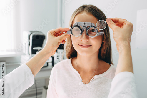 Teenage girl,twelve years old, having her eyesight examining. Children eye examination procedure, real patients