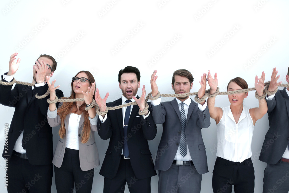 scared group of business people tied with a rope. scared group of business people tied with a rope.