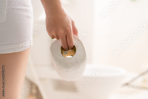 Photos Cropped image of woman's hand take toilet paper in the bathroom