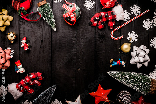 festive celebration background with christmas decorating items on black vintage wooden floor with free copy space