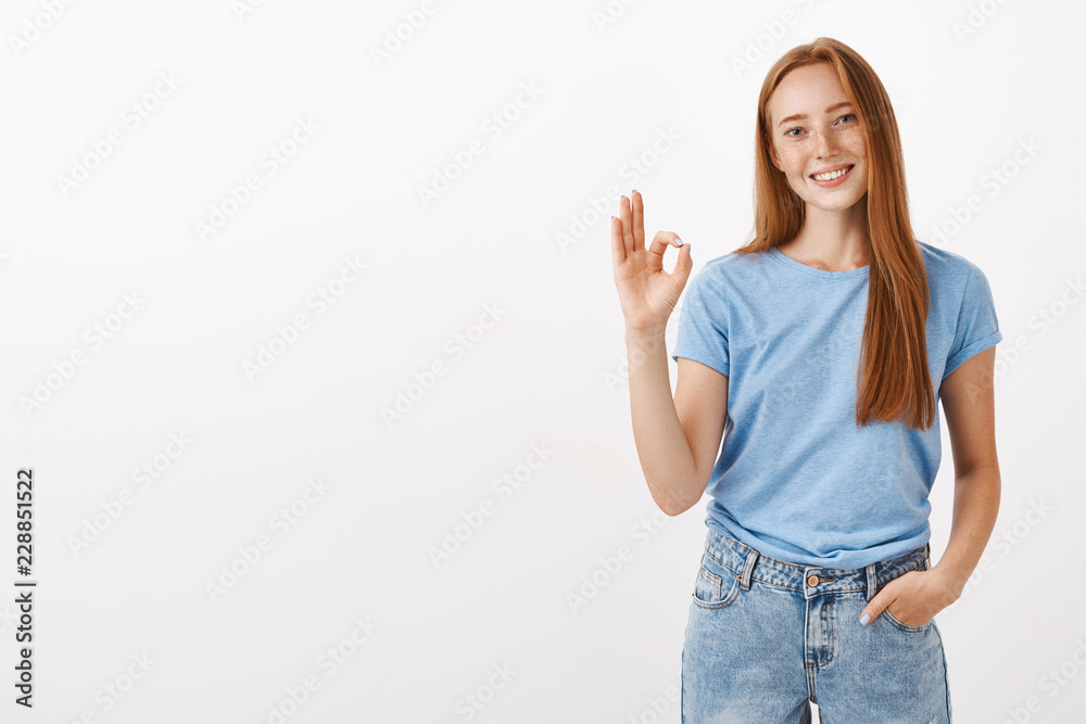 Ok no problem. Portrait of friendly and joyful good-looking redhead girlfriend with freckles holding hand in pocket having casual talk assuring work be done in time showing okay or excellent gesture Ok no problem. Portrait of friendly and joyful good-looking redhead girlfriend with freckles holding hand in pocket having casual talk assuring work be done in time showing okay or excellent gesture