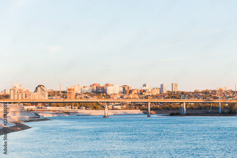 Cityscape, blue river and bridge on high apartments