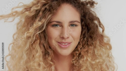 happy smiling laugnig model in studio. slowmotion from 60 fps. Curly blonde hair