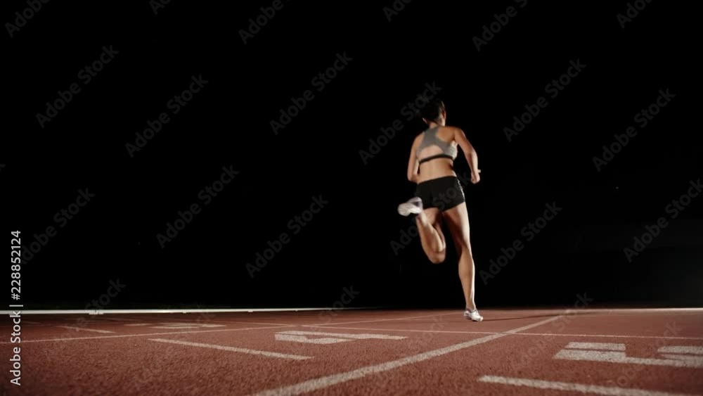 Athlete running on short track. Young south asian runner heading forward on track of sports arena, preparing for competition - fitness, sports concept