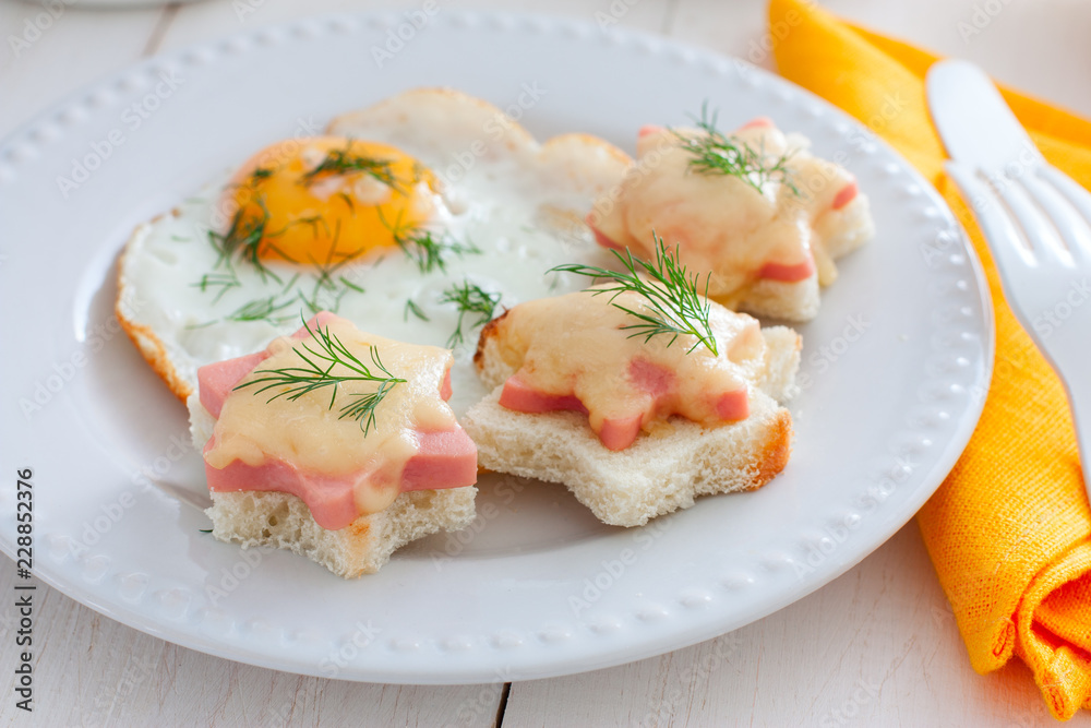 Breakfast with fried egg and hot sandwiches with sausage and cheese, horizontal