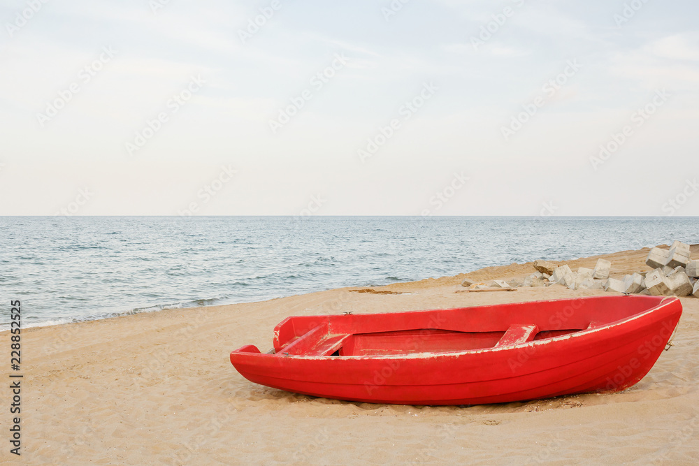 Old red boat on the beach, waves on the water and sky background Old red boat on the beach, waves on the water and sky background