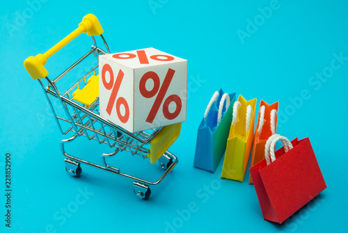 Shopping in plaza and complex department store in fashion lifestyle sale promotion season concept. Percentage (%) box in trolley on blue background. Shopaholic love 50% off brand name sale promotion