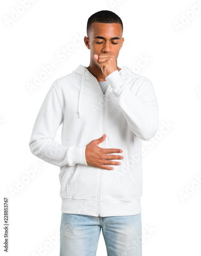 Dark-skinned young man with white sweatshirt is suffering with cough and feeling bad on isolated white background