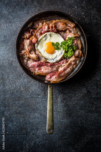 Top of view roasted bacon and egg with herbs.