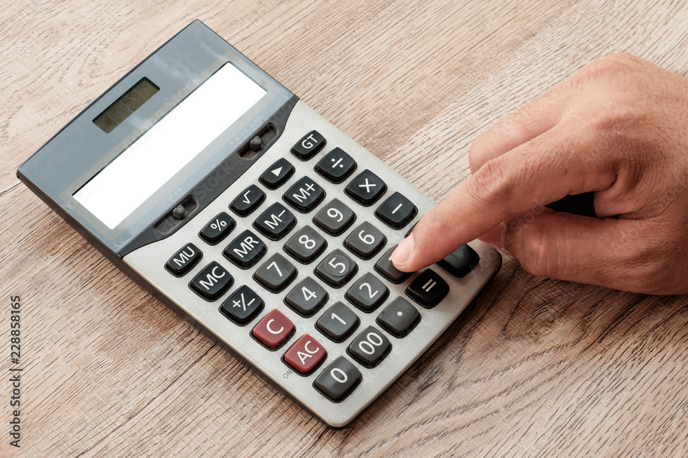 Pointing finger is pressing white screen calculator. Pointing finger is pressing white screen calculator.