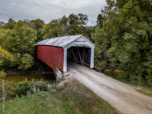 A covered bridge spanning a river nestled in the trees in Indiana, USA
