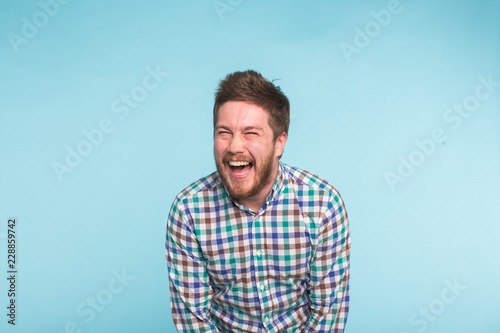 Murais de parede Emotion, people and fun concept - Young handsome man laughing on blue background