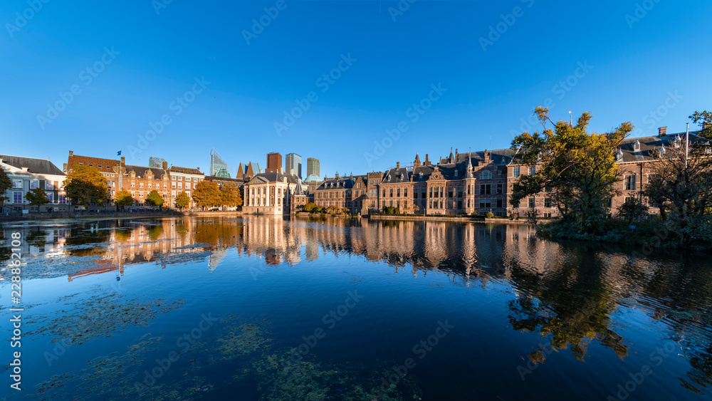 Reflection of the Buitenhof, Binnenhof buildings, Dutch parliament campus under a clear blue sky in The Hague, Netherlands
