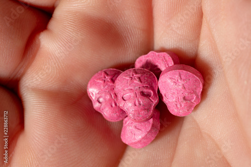 Red Army Skull, Ecstasy, pain killer or xtc pills in the palm of a caucasian hand. 