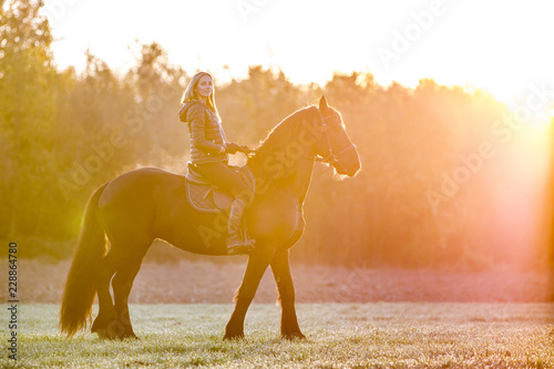 Bild auf Leinwand Woman riding a horse in park