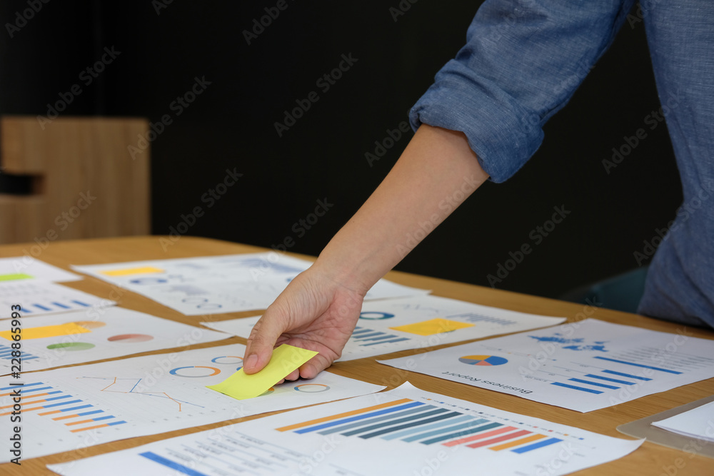 Businessman holding sticky note on business document. paper reminder schedule for creativity idea Businessman holding sticky note on business document. paper reminder schedule for creativity idea